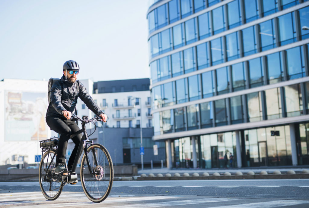 Mannlig syklist, sykler til jobb en solfylt dag